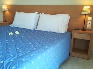 1 cama con sábanas azules y 2 almohadas en Olympia en Edessa