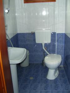 a blue tiled bathroom with a toilet and a sink at Family Hotel Shisharka in Batak