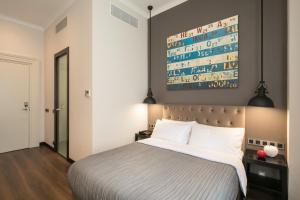 a bedroom with a bed and a painting on the wall at Quentin Prague Hotel in Prague