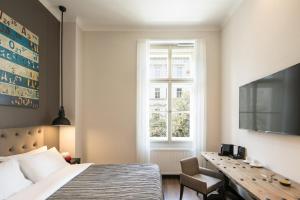 Schlafzimmer mit einem Bett, einem Schreibtisch und einem Fenster in der Unterkunft Quentin Prague Hotel in Prag