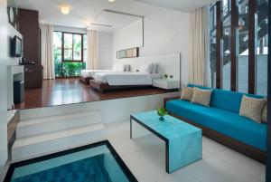 a living room with a bed and a blue couch at Z Through By The Zign in Pattaya North