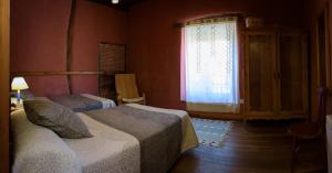 a bedroom with two beds and a window at Casa Rural Caenia Grupos in Traguntia