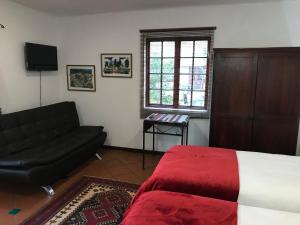 uma sala de estar com uma cama e um sofá em Greenwoods Self-Catering em Pretoria