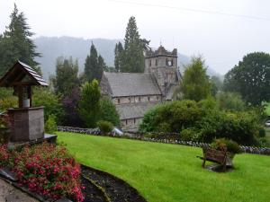 an old building with a clock tower in a park at Church Hill House in Betws-y-coed