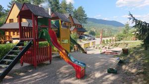 a playground with a slide in front of a house at Drevenice Amálka v Terchové in Terchová