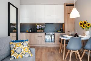 a kitchen with a table and a dining room at Art Apart River View Wrocław in Wrocław