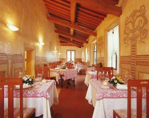 una sala da pranzo con tavoli e sedie con fiori di Hotel Villa San Lucchese a Poggibonsi