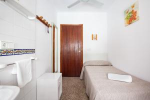 a small bathroom with two beds and a sink at Hostal Las Nieves in Ibiza Town