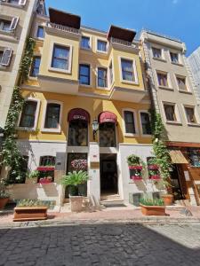 a yellow and white building with potted plants at Ottopera Hotel in Istanbul