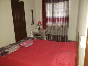 um quarto com uma cama vermelha com uma mesa e uma janela em Villa Pte Aux Piments em Pamplemousses Village
