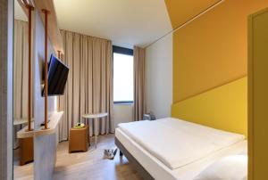 a hotel room with a bed and a tv at ibis budget Bremen City Center in Bremen