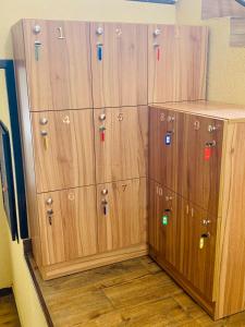 - une rangée de casiers en bois avec des clés colorées dans l'établissement Monada Hotel & Hostel, à Oujhorod