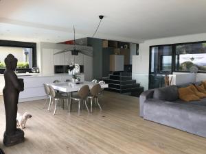 a living room and kitchen with a table and a couch at Villa de luxe avec piscine, vue imprenable in Séné