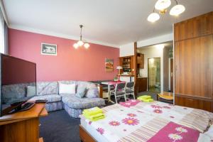 a living room with a bed and a couch at Penzion Menšík in Kroměříž