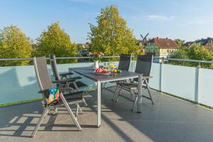 a table and chairs on a balcony with a view at Luxus_SPA_OG_Fewo QUARTIER 4 _WE 4_ in Göhren-Lebbin