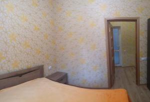 a bedroom with a bed and a mirror at On Sevastopolskoy in Gelendzhik