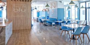 a restaurant with blue chairs and tables in a room at Prywatne apartamenty w hotelu - 365PAM in Sarbinowo