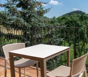a table and chairs on a balcony with a view of a hill at Hostal Cal Franciscó in Gósol