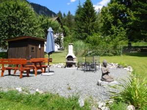 a patio with a bench and an umbrella and a grill at Ferienhaus Bella Vista in Presseggersee