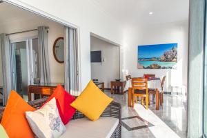 a living room with a couch with colorful pillows at Treasure Island Retreat in Anse Kerlan