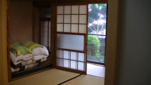 a room with a window with a bed in it at Minshuku Chatamago in Nagasaki