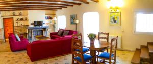 sala de estar con muebles de color rojo y mesa en El Chalet del Pinar, en Cuenca