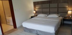 a bedroom with a large bed and a bathroom at Al Somow Chalets in Dahaban