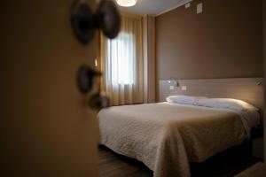 1 dormitorio con cama y ventana en Magic Hotel, en Atena Lucana