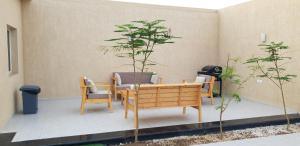 a patio with a table and chairs and a tree at Al Somow Chalets in Dahaban