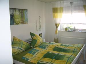 a bed with a yellow and green comforter in a bedroom at Ferienhaus Mosel/Trittenheim in Trittenheim +13 photos