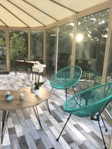 een patio met 2 groene stoelen en een tafel bij ker corre in Étables