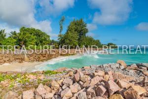 
a rocky shoreline with rocks and a waterfall at Treasure Island Retreat in Anse Kerlan
