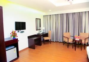 Triguna Clarks Inn Kurnool的电视和/或娱乐中心