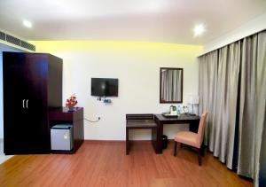 Triguna Clarks Inn Kurnool的电视和/或娱乐中心