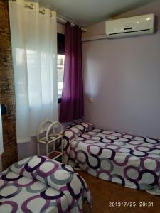 2 camas individuales en una habitación con ventana en Andrea´s place en Ciudad Real