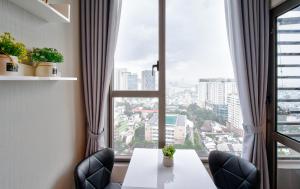 a table and chairs in a room with a large window at Saigon Banhada - Rivergate - Infinity Pool in Ho Chi Minh City