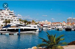 Un barco está atracado en un puerto deportivo con barcos. en Apartamento dentro da Marina de Vilamoura, en Vilamoura