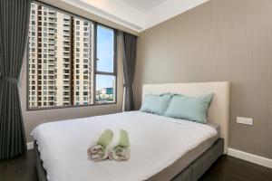 a bedroom with a large bed with slippers on it at Saigon Banhada - Rivergate - Infinity Pool in Ho Chi Minh City +104 photos