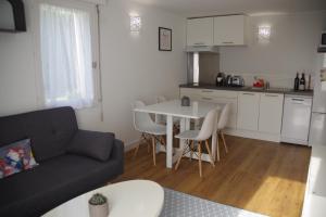 a living room with a couch and a table and a kitchen at Gîte la Briantaise in Saint Malo