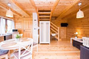 a kitchen and dining room with a table and chairs at domki letniskowe Ustka Sosnowo in Ustka
