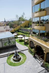 einen Blick über ein Gebäude mit einem Innenhof mit einem Brunnen in der Unterkunft El Cabildo Hotel in Arequipa