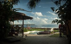 - une plage avec une cabane en paille et l'océan dans l'établissement Simeulue Surflodges, à Lasikin