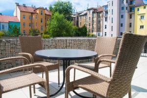 a table and chairs on a patio with buildings at Sunny, fully furnished Studio type with terrace in Pilsen