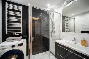 a bathroom with a washing machine and a sink at MIRA APARTMENTS in Gdańsk +13 photos