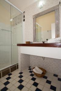 a bathroom with a shower and a sink and a mirror at Pousada Costa do Sapê in Angra dos Reis