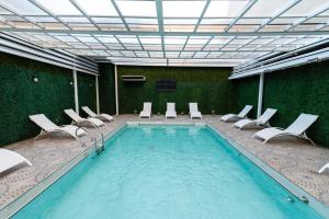 a swimming pool with chairs and a tv in a building at Ker San Telmo Hotel in Buenos Aires