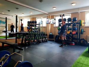 a man is in a gym with a barbell at Penzion FIT - Contactless check in in Zvolen