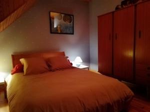 a bedroom with a large bed and a cabinet at Maison typique pleine de charme Peyrusse Cantal in Peyrusse