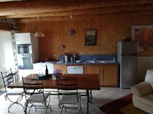 een keuken en eetkamer met een tafel en stoelen bij Maison typique pleine de charme Peyrusse Cantal in Peyrusse