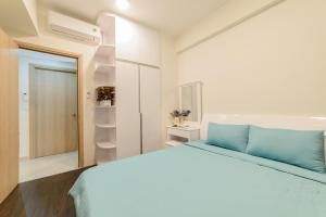 1 dormitorio blanco con 1 cama grande con almohadas azules en Saigon Banhada - Rivergate, en Ho Chi Minh